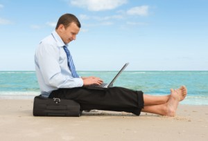 young businessman working with laptop on the beach